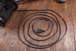 power wire of black vacuum cleaner on wooden surface photo