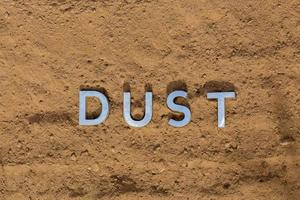 the word dust on dusty road surface in flat lay perspective photo