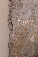 the word mud imprinted in wet dirt road surface - close-up with selective focus photo