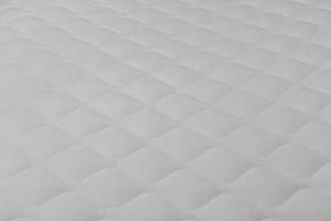 Soft white mattress close-up background with selective focus. photo