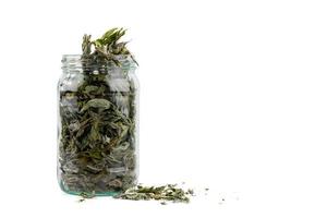 glass jar of dryed natural mint leaves isolated on white background photo