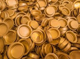 pile of stamped thin sheet brass hat-shaped semimanufatures, closeup with selective focus and blur photo
