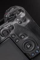 modern professional black digital photo camera controls - buttons, dials, wheels, screens and joystick - close-up macro view