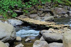 un puente que cruza un río que todavía es muy hermoso foto