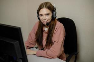 A happy call center agent working on a support hotline in the office. The call center operator is talking to the customer. photo