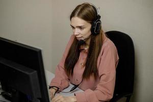 A happy call center agent working on a support hotline in the office. photo