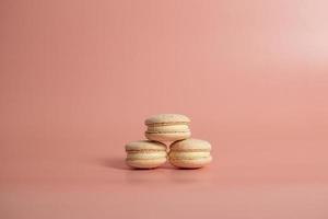 Round beautiful sweets macaroni on a pink background. Still life with macaroni cakes and different flower. Copy space. Banner photo