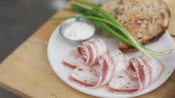 Pancetta green onions and toast plated on a white dish with sauce on the side video