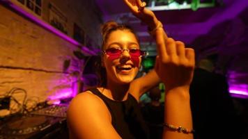 vrouw in zonnebril zingt en dansen in een club partij video