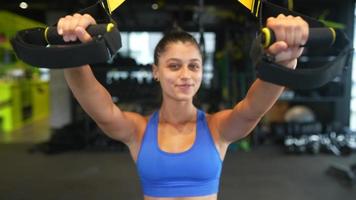 Young fit woman exercises in gym using equipment