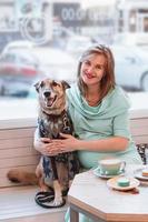 retrato de mujeres caucásicas embarazadas sonrientes con su perro en el café. estilo de vida embarazada. foto