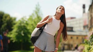 Frau geht an einem sonnigen Tag mit Rucksack auf dem Weg im Freien video