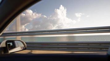 vista da janela lateral de um carro dirigindo rápido ao longo da estrada durante um belo céu e campo. viagem de viagem e conceito de aventura. video