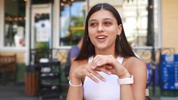 mujer sentada en un café al aire libre hablando y haciendo gestos con las manos contando una historia video