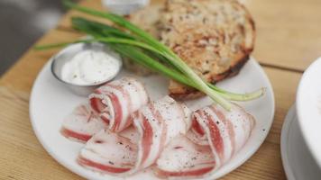 Pancetta green onions and toast plated on a white dish with sauce on the side video