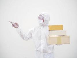 joven con uniforme de suite de ppe mientras sostiene cajas de cartón con guantes médicos de goma y máscara. concepto de coronavirus o covid-19 fondo blanco aislado foto