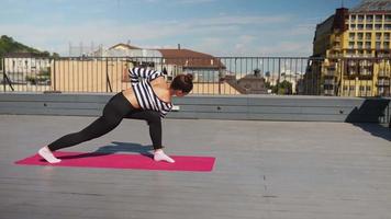 Woman stretches on yoga mat on an outdoor deck video