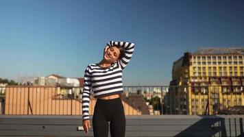 Woman stretches on yoga mat on an outdoor deck video