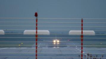 avión acelerando para despegar temprano en la mañana. pista desde el final, vista a través de las luces de aterrizaje video