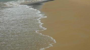 à beira-mar, a onda rola sobre a costa arenosa. conceito de turismo e viagens. video