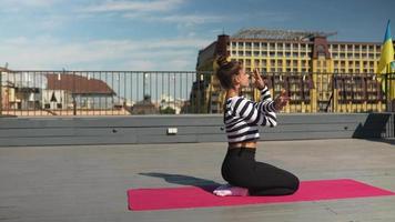 Pan around woman stretching on yoga mat on an outdoor deck video