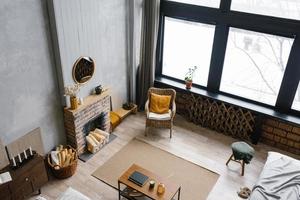 Modern country villa in Scandinavian style grey minimalist interior with fireplace and white stucco wall. View of the living room from above, from the second floor photo