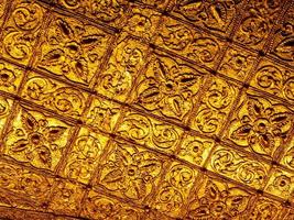 Beautiful Burmese art pattern motifs decorative design on the golden walls of the rooms in the temple photo