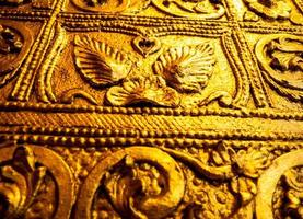 Beautiful Burmese art pattern motifs decorative design on the golden walls of the rooms in the temple photo