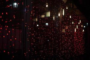 Garland on window. Red lights. Texture of small lamps. Window details. photo