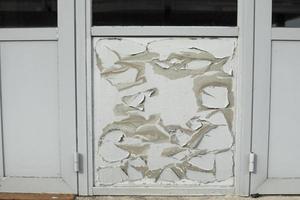 Flying paint. Damaged surface of door. Gray paint has aged. photo