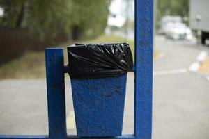 Urn with bag. Place for garbage. Trash can with black bag. Public garbage on street. photo