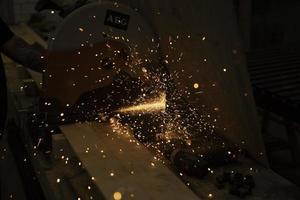 Sparks from sawing metal. Lights in dark. photo