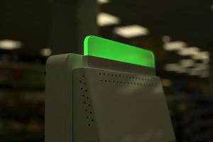 Green light payment device. Device for paying for purchases. Store details. Market interior. Neon color. photo