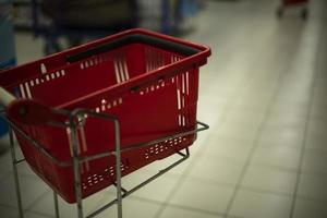 Basket for products. Red basket in store. Shopping cart parts. photo