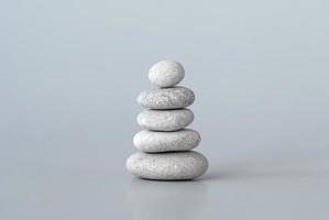 pila de guijarros sobre fondo gris, concepto mínimo de meditación de equilibrio zen foto