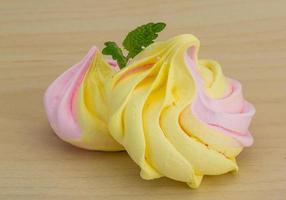 Meringue on wooden background photo