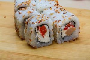 California roll on wooden board and wooden background photo