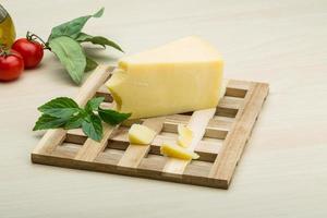 Parmesan cheese on wooden board and wooden background photo