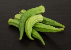 Okra vegetables on wooden background photo