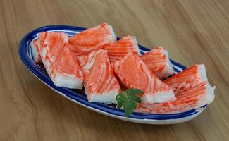 Crab sticks in a bowl on wooden background photo