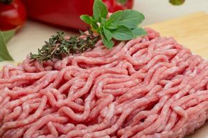 Minced meat on wooden board and wooden background photo