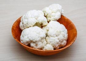 Cauliflower in a bowl on wooden background photo