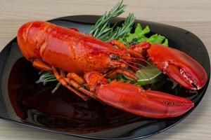 Boiled lobster on the plate and wooden background photo