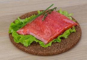 Salmon on wooden board and wooden background photo