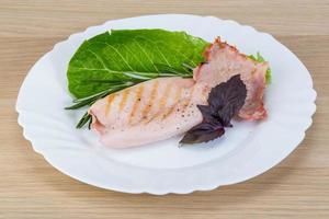 Grilled squid on the plate and wooden background photo