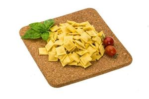 Ravioli on wooden board and white background photo