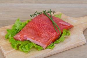 Salmon on wooden board and wooden background photo