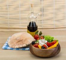 Greek salad in a bowl on wooden background photo