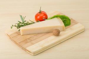 Parmesan cheese on wooden board and wooden background photo