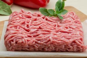 Minced meat on wooden board and wooden background photo